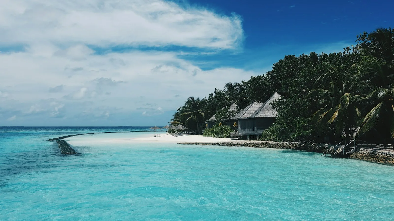 Famille avec deux enfants sur une plage de sable blanc aux Maldives
