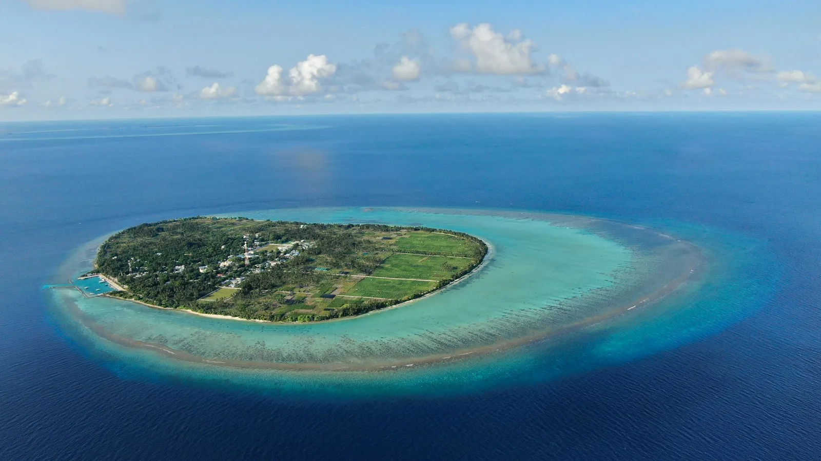 Speedboat sur un lagon turquoise entre deux îles locales des Maldives